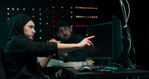 Young Adults Working at Computer Eating Pizza