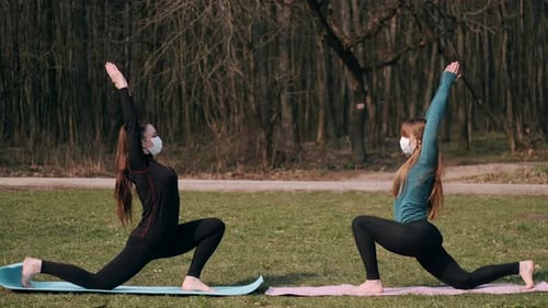 Women Doing Yoga Exercise Outdoors in Park