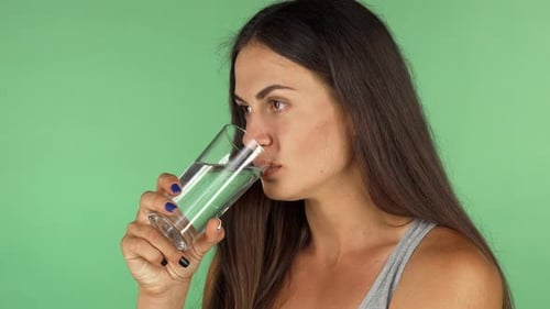 Wunderschöne junge Frau trinkt gerne frisches, sauberes Wasser