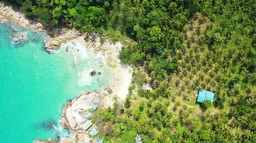 Luxury flying travel shot of a white sandy paradise beach and blue water background in 4K