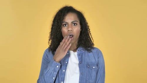 Woman Reacting with Surprise in Front of Yellow Background