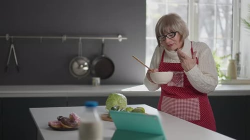 Senior Woman Video Calling While Cooking at Home