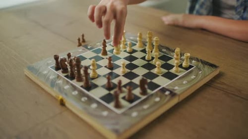 Young Man Wearing Glasses Plays Chess Alone With Himself At Home