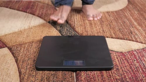 Man's Feet on Weight Scale Close Up