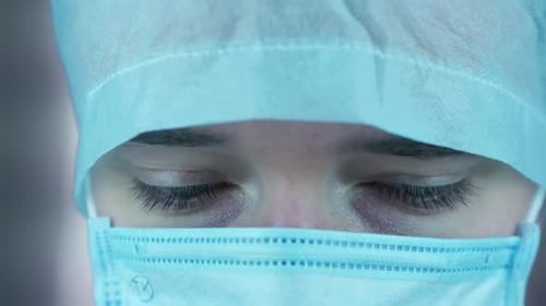 Focused Eyes of Surgeon Wearing Surgical Cap and Mask