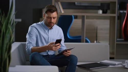 Corporate Man Calling Phone Looking Tablet Research Business Data in Home Office