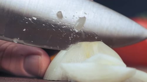 Slicing White Onion with Silver Knife Close Up