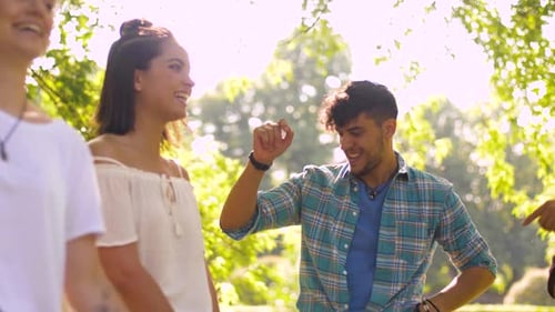 Happy Friends Dancing at Summer Party in Park