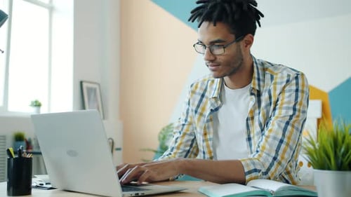 Afro-American Man Entrepreneur Working with Modern Laptop in Office Typing
