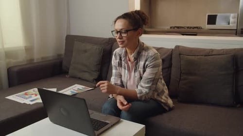 Woman Presents Charts During Video Conference at Home
