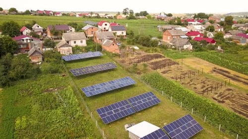 Aerial view of a row of blue solar panels installed on the ground in residential area.