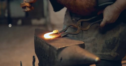 Blacksmith Shaping Hot Metal on Anvil