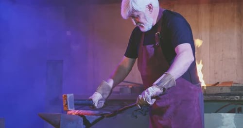 Blacksmith Forging Hot Metal with Hammer on Anvil