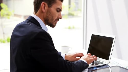 Businessman working on laptop at desk 4k