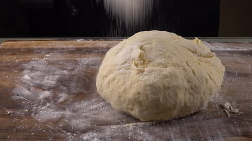 Hands Kneading Dough on Floured Cutting Board