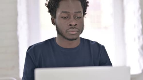 Close Up of African Man Typing on Laptop