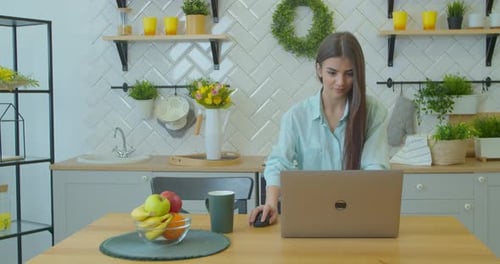 Woman Working on Laptop in Bright Kitchen
