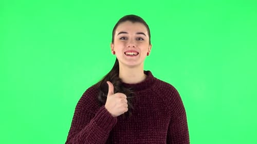 Junge fröhliche Frau zeigt Daumen hoch, Geste wie. Greenscreen
