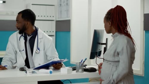 Pregnant Woman Talking to Doctor During Checkup