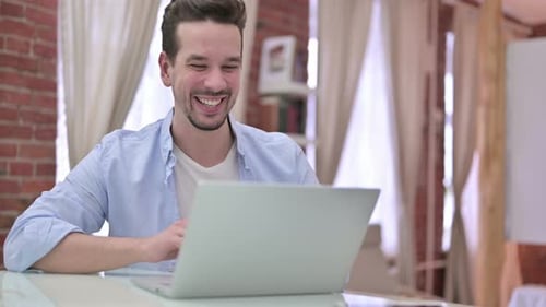 Smiling Young Adult Video Conferencing on Laptop
