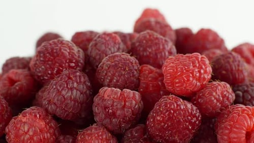 Schöne reife Himbeere dreht sich auf einem Teller. Langsame Rotation der Himbeeren Nahaufnahme von oben.