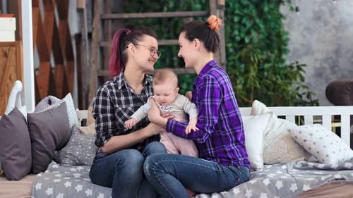 Two Women Sitting With Baby on Swing Bench
