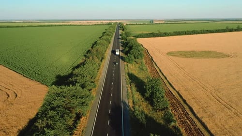 Flying High Over the Asphalt Road Among the Fields