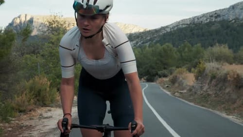 Young Professional Female Cyclist on Road Training