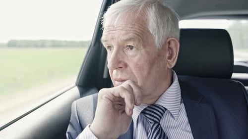 Senior Man Riding in Car Through Countryside