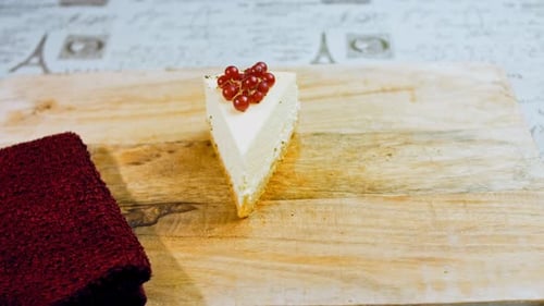 Cheesecake Slice Topped with Red Currants on Board