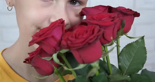 Happy Child Smelling Red Roses Close Up