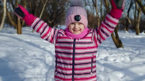 Lächelndes Kind, das Spaß hat Spaß beim Tanzen Herumalbern auf der verschneiten Straße im Winter Park Forest