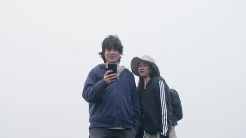 Couples of Asian tourists enjoy taking photos on top of the mountain with thick.