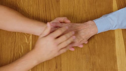 Young Hand Holding the Hand of a Senior