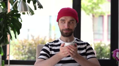 Man Enjoying Warm Drink Indoors on Bright Day