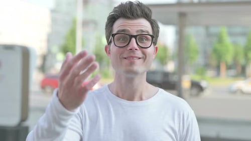 Young Man Beckoning Forward in the City