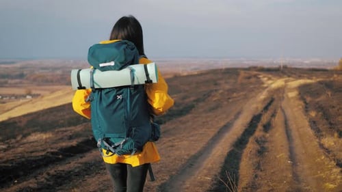 Woman Hiking With Backpack in Rural Landscape
