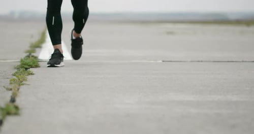 Athletic Runner Running on Concrete Track