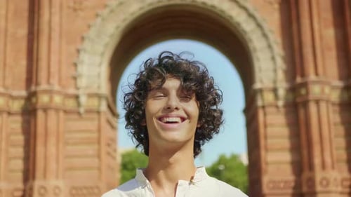 Portrait of Joyful Man Laughing Outdoor. Cute Man Smiling at Urban Background.