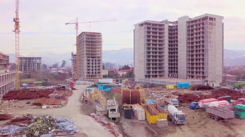 Drone view of construction of multi-storey buildings background of mountains.