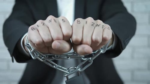 Man in Suit Fists Clenched, Bound by Chains