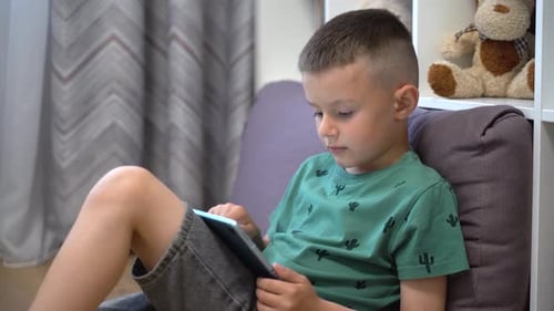 Boy surfing the net, kid with tablet