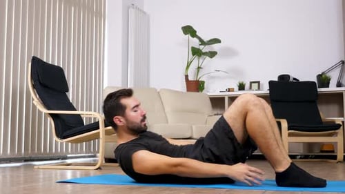 Mann macht Sport zu Hause, er macht Übungen für die Bauchmuskeln