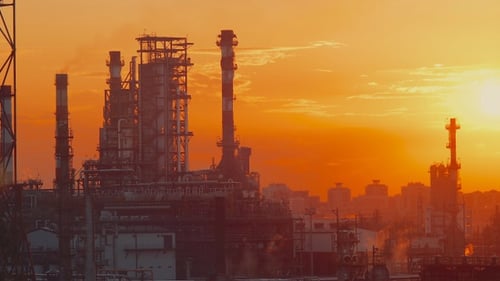 Industrial Plant and City at Sunset