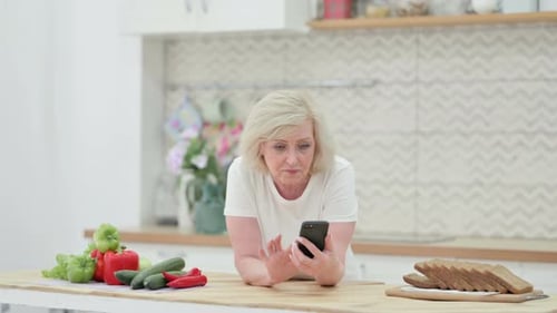 Woman Using Smartphone in Bright Kitchen