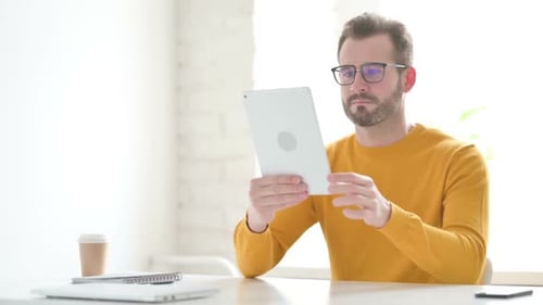 Man Using Tablet While Sitting in Office