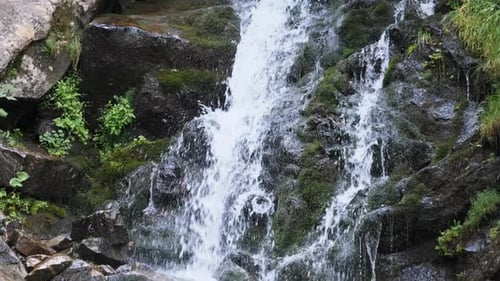 Wilder Berg-Wasserfall. Schnell fallendes Wasser trifft auf die Steine. Zeitlupe