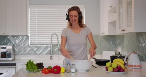 Woman Making Salad and Dancing in the Kitchen