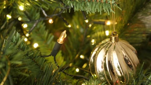 Shiny decorative golden bauble on the artificial tree close-up 4K 2160p 30fps UltraHD footage - Ch