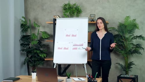 Businesswoman Presenting Data Charts in Office